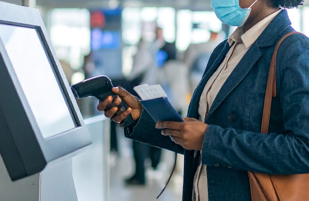 Firefly a passenger at an airport stood at an airport self service kiosk scanning their boa 992715 e1754408014816